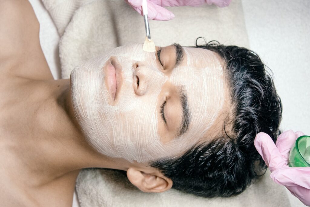 A man getting a facial mask on his face